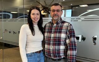 Anniken and Mark standing together in a modern office space.