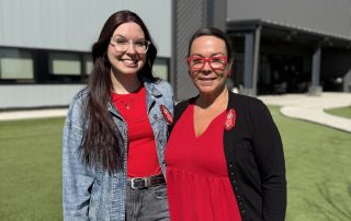 Bela and Denise standing outside a modern commercial building.